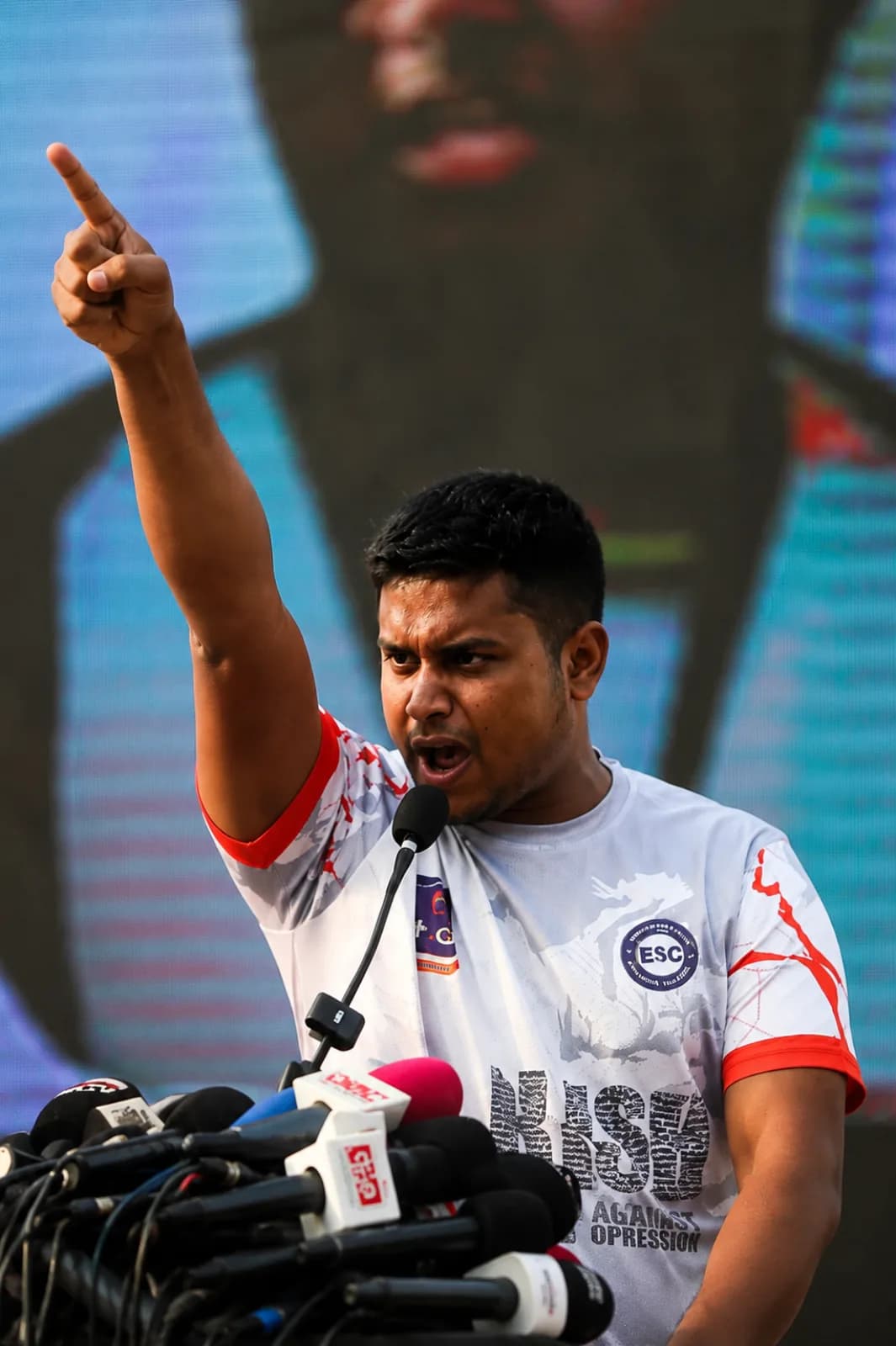 Hasnat Abdullah addressing a rally, finger raised toward the sky